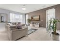 Comfortable living room featuring a modern sofa, stylish decor, and natural light from large windows at 14318 Fieldstone Lake Way, Orlando, FL 32824