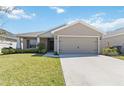 Charming single-story home with a well-manicured lawn, a two car garage and neutral colored exterior at 1575 Eucalyptus Way, Davenport, FL 33837