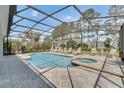 Enclosed pool area featuring a large pool, jacuzzi, tile flooring, and ample seating at 174 Yellow Snapdragon Dr, Davenport, FL 33837