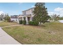 Attractive two-story home with a covered front porch, lush lawn, and mature tree at 1893 Rafton Rd, Apopka, FL 32703