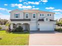 Charming two-story home with a three-car garage and well-manicured front yard at 2189 Weatherly Way, Orlando, FL 32820