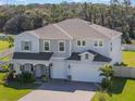 Stunning two-story home with a three-car garage and lush green lawn at 2189 Weatherly Way, Orlando, FL 32820