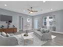 Cozy living room featuring a modern ceiling fan, stylish furniture, and ample natural light at 2430 Park Ave, Indian Lake Estates, FL 33855