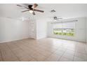 Bright and airy living room featuring tile flooring and multiple ceiling fans at 2900 E Grant Ave, Orlando, FL 32806