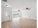Spacious living room with tile floors, two ceiling fans, and a large window at 2900 E Grant Ave, Orlando, FL 32806