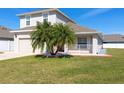 Inviting two-story home with a green lawn and tropical palm trees enhancing the curb appeal at 3006 Mandolin Dr, Kissimmee, FL 34744