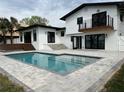 Backyard pool area with patio, landscaping, second story balcony and home exterior at 382 Riverside Dr, Ormond Beach, FL 32176