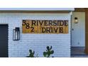 Close-up of the address sign on white brick with a modern exterior light at 382 Riverside Dr, Ormond Beach, FL 32176
