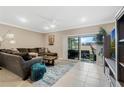 Inviting living room with tile flooring, neutral tones, comfortable seating, and sliding doors to the outdoor space at 4715 Coral Castle Dr, Kissimmee, FL 34746