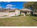Inviting single-story home boasting an attached two-car garage, well-kept lawn and mature trees at 545 Ne 45Th Ct, Ocala, FL 34470
