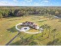 Expansive estate with a grand home, circular drive, lush grounds, and mature trees, providing privacy and scenic beauty at 5500 State Road 33, Clermont, FL 34714
