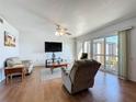 Bright living room with wood-look flooring, ceiling fan, and sliding glass doors to the outside at 562 Orange Dr # 33, Altamonte Springs, FL 32701