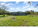 Charming blue single-Gathering home with a well-maintained lawn and a welcoming fire pit at 7322 Groveland Farms Rd, Groveland, FL 34736