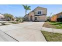 Exterior elevation of a two-story home with an attached garage, well-kept lawn, and a classic architectural style at 877 Scrub Jay Way, Davenport, FL 33896