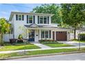 Charming two-story home with a well-manicured lawn, brick pathway, and a two car garage at 900 Golfview St, Orlando, FL 32804
