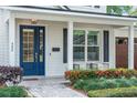 Charming front porch with a blue door, beautiful landscaping, and a welcoming seating area at 900 Golfview St, Orlando, FL 32804