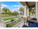 Inviting covered porch with cozy seating, offering a relaxing view of the quiet neighborhood street at 10078 Greenshire Way, Orlando, FL 32827