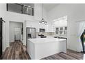 Open kitchen features modern appliances, white cabinets, large island, and high ceilings at 1070 Lake Ariana Blvd, Auburndale, FL 33823