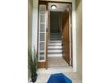 Inviting entryway with a side window, a wood-look door and tile flooring that leads to the stairs at 10711 Yellow Tiger Lily Dr # S, Orlando, FL 32832