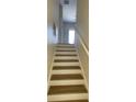 Stairway with light wood stairs and white risers, leading to the upper level of the home at 10711 Yellow Tiger Lily Dr # S, Orlando, FL 32832