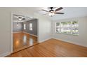 The Dining room has Hardwood floors, a ceiling fan, and bright light from the windows at 1111 Guernsey St, Orlando, FL 32804