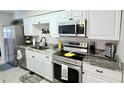 Updated kitchen boasts granite countertops, stainless steel appliances, and modern cabinetry at 1420 Continental Dr, Daytona Beach, FL 32117