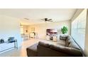 Bright living room featuring laminate flooring and large windows with a comfortable, oversized couch at 1420 Continental Dr, Daytona Beach, FL 32117