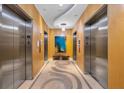 Modern elevator lobby with decorative flooring, wood paneling, and an art display at 150 E Robinson St # 2308, Orlando, FL 32801