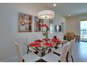 Chic dining area featuring modern art, pendant lighting, and a glass table for stylish entertaining at 1523 Still Dr, Clermont, FL 34714
