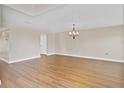 Spacious living room featuring sleek flooring, neutral walls, and a decorative light fixture at 1705 Ridgemoor Dr, Mascotte, FL 34753