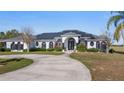 Stunning single-story home featuring modern architectural style, circular driveway, solar panels, and lush landscaping at 17117 Heartwood Loop, Winter Garden, FL 34787