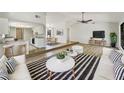 Open-concept living room featuring hardwood floors, ceiling fan, and breakfast bar connecting to the modern kitchen at 1738 Athens Ct, Lakeland, FL 33803