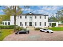 An exterior shot of a two-story white home with brick driveway and manicured landscaping at 1943 Wingfield Dr, Longwood, FL 32779