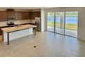 Spacious kitchen and open floor plan with stainless steel appliances and a large island overlooking a beautiful lake view at 1988 Iorio Dr, St Cloud, FL 34771