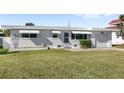 A well-maintained single-story home with white brick, awnings, and a manicured lawn at 3226 S Peninsula Dr, Daytona Beach Shores, FL 32118