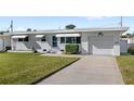 A charming single story home with a well-manicured lawn, white brick exterior, and a one-car garage at 3226 S Peninsula Dr, Daytona Beach Shores, FL 32118