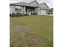 Charming single-story home with gray exterior, landscaped yard, and covered front porch with rocking chairs at 4590 Sw 99Th St, Ocala, FL 34476