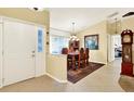 Inviting foyer with tile flooring leading into a dining area with wood furniture and neutral colored walls at 4721 Tara View Road, Leesburg, FL 34748