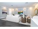 Elegant living room featuring modern decor, a large TV, recessed lighting, and stylish furniture at 5006 Legacy Oaks Dr, Orlando, FL 32839
