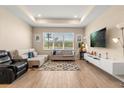 Bright living room features tile flooring, a tray ceiling, neutral paint and large windows for natural light at 5058 Sparkling Water Way, Kissimmee, FL 34746