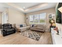 Bright living room features tile flooring, a tray ceiling, neutral paint and large windows overlooking a pond at 5058 Sparkling Water Way, Kissimmee, FL 34746