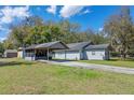 Rear view of cozy single-story home with covered carport and spacious grassy yard at 519 Pearl St, Mascotte, FL 34753