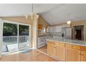 Bright kitchen featuring white appliances, center island, and sliding door to the deck at 519 Pearl St, Mascotte, FL 34753