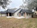 Charming single-story home featuring a dark roof, stone accents, solar panels, and a large yard at 1102 Hamlin Ave, Howey In The Hills, FL 34737