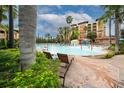 Resort-style pool area with palm trees, splash fountain, and comfortable lounge chairs at 12527 Floridays Resort Dr # 401E, Orlando, FL 32821