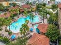 Aerial image showcases a large community pool surrounded by palm trees and lounge chairs at 12527 Floridays Resort Dr # 401E, Orlando, FL 32821