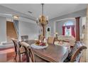 Spacious dining room featuring hardwood floors, a chandelier, and views into the living area at 1420 Prairie Oaks Dr, St Cloud, FL 34771