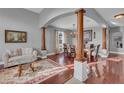 Elegant dining room featuring rich hardwood floors, decorative columns, and a stylish chandelier at 1420 Prairie Oaks Dr, St Cloud, FL 34771