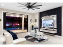 Modern living room with wall-mounted TV, stylish decor, and access to the outdoor pool at 19313 Pummelo Dr, Orlando, FL 32827