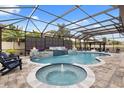 Screened pool area with waterfall feature, fire bowls, hot tub, and covered lounge area at 19313 Pummelo Dr, Orlando, FL 32827
